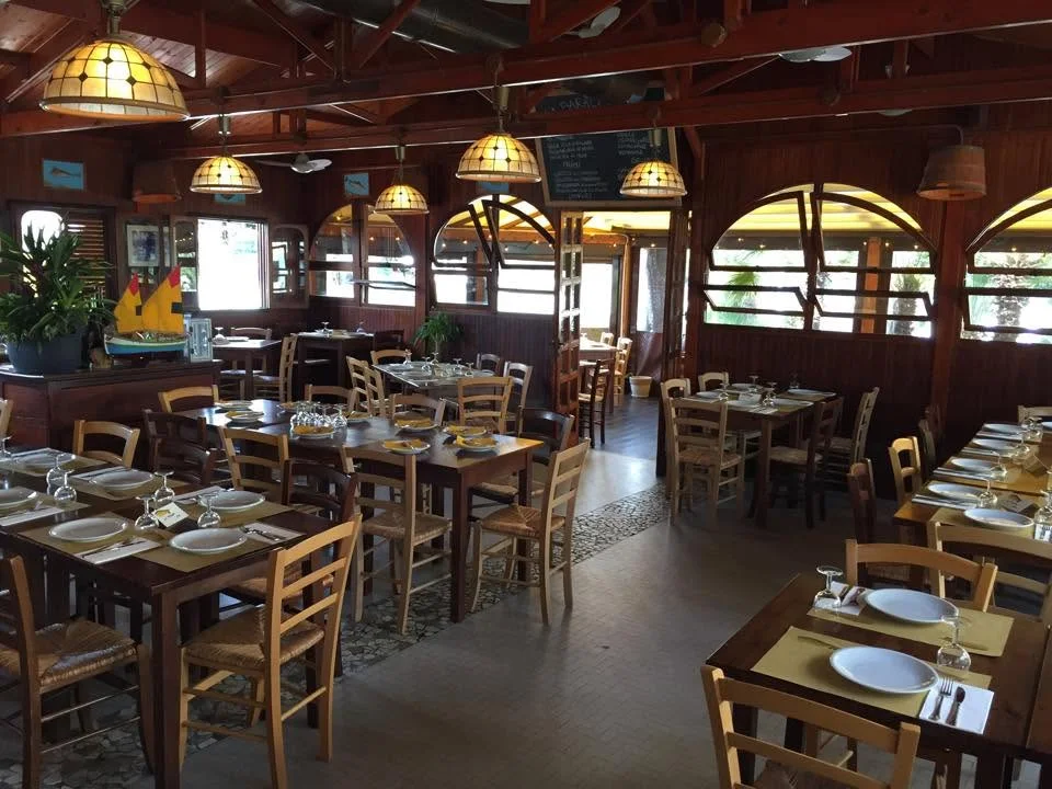 La sala apparecchiata della Baracca, tra legno e luce